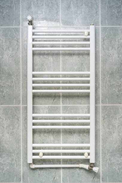 istock White radiator hung on the wall in a bathroom with green ceramic tiles 2193810079