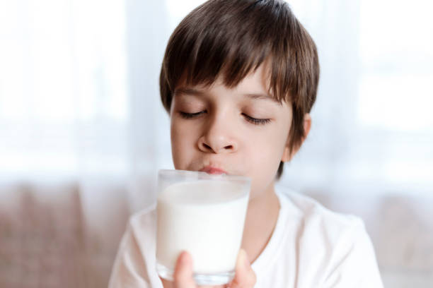 istock Cute boy drinking milk from a glass at home 2193810464