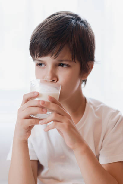 istock Cute boy drinking milk from a glass at home 2193810467
