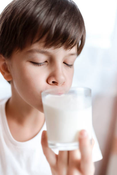 istock Cute boy drinking milk from a glass at home 2193810484