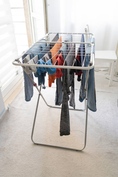 istock Laundry drying on an indoor clothes rack, with various garments including jeans and shirts 2193810893