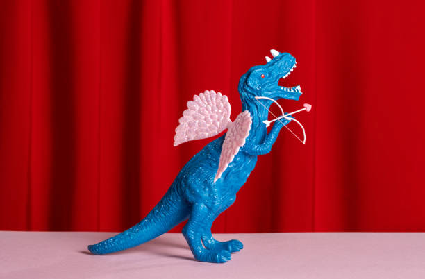 istock Blue dinosaur with pink wings with bow and arrow 2193811417
