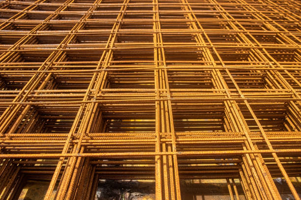 Rusty rebar grid used in construction for reinforcing concrete structures, showcasing the intricate pattern and texture of the steel bars