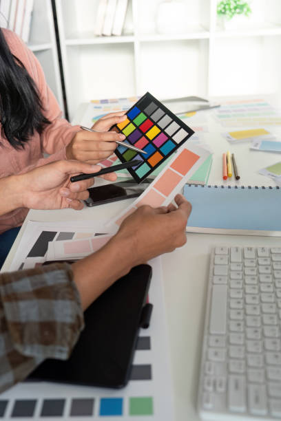 istock Creative design team collaborates on graphic color selection in modern office space 2193813226