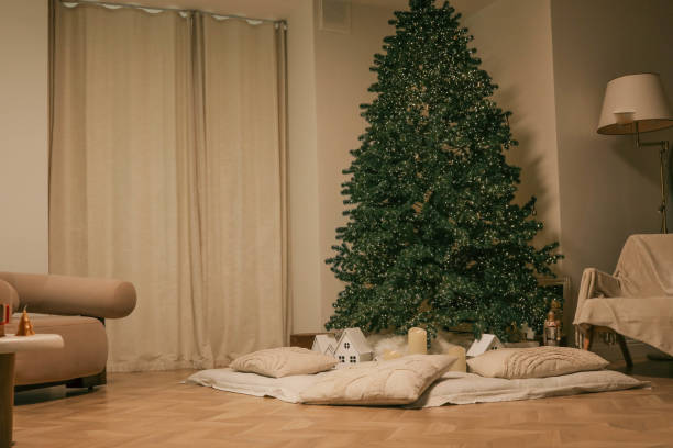 istock Minimalistic Christmas interior with a lit Christmas tree, soft pillows, glowing candles, and small decorative houses, creating a cozy and festive atmosphere 2193813994