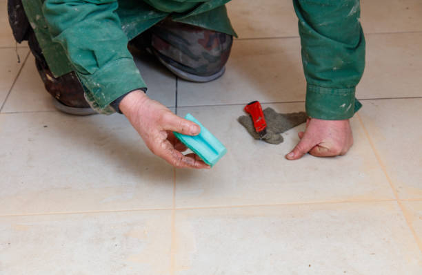 istock A man is kneeling on the floor and holding a green sponge 2193814728