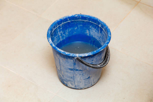istock A blue bucket with water in it is sitting on a tile floor 2193814762
