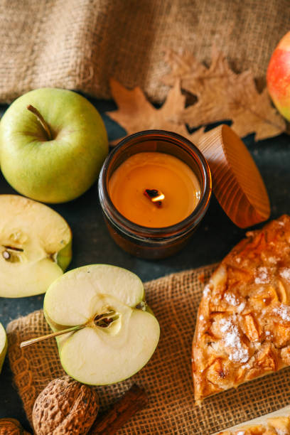 istock A cozy autumn setup featuring a freshly baked apple pie surrounded by apples, walnuts, a candle, and a warm drink 2193814942