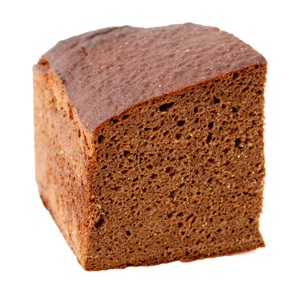A brown cake with holes in it. The cake is cut into a square shape