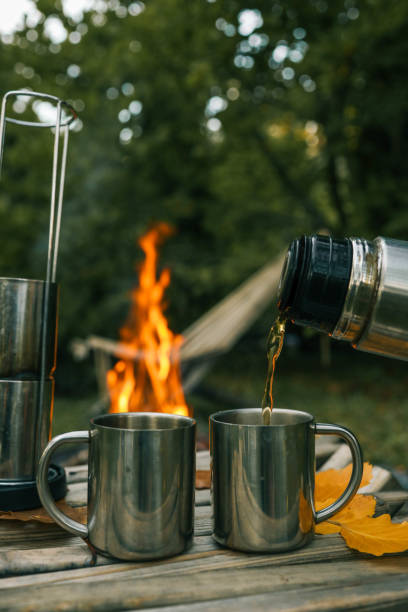 istock Themed trip. The man pours a hot drink into the thermos 2193815602