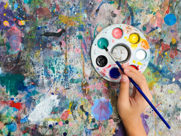 istock Artist hand holding paintbrush over palette 2193816579