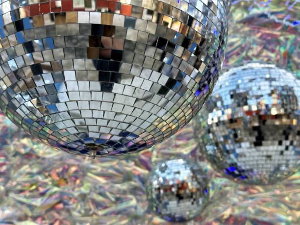 istock Close-up shot of a disco ball reflecting light and colors. The image features multiple disco balls of varying sizes, creating a dazzling and vibrant composition. 2193817128