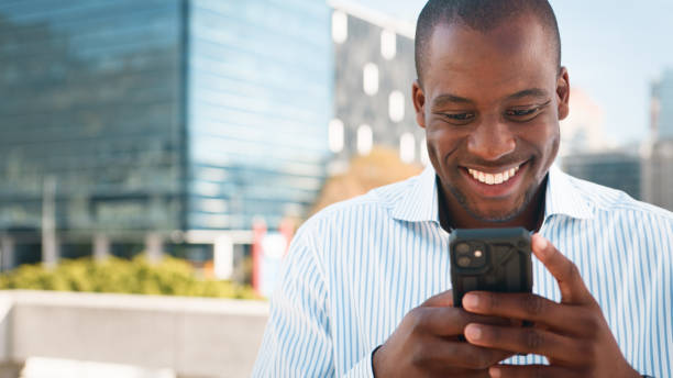 istock Businessman Smiling While Checking His Smartphone Outdoors in a Modern Urban Setting 2193820454