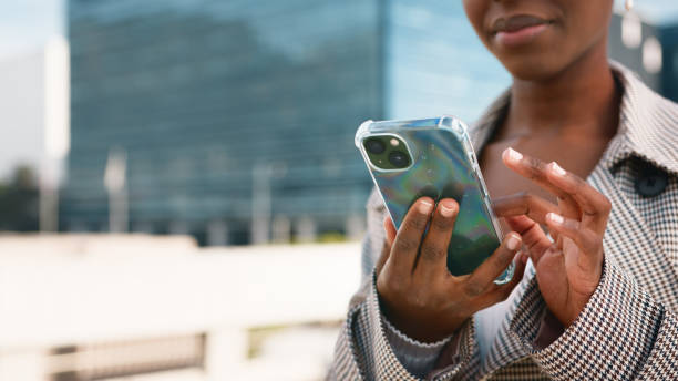 Close-Up of Woman Using Smartphone Outdoors in Modern Urban Environment