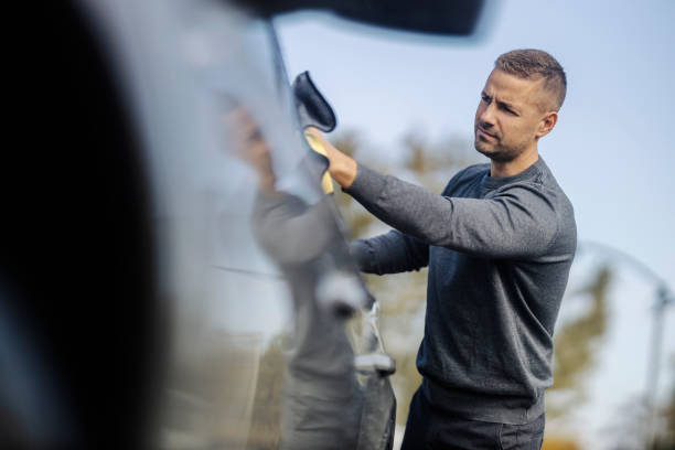 istock A young neat guy is rubbing car windows with microfiber cloth at car wash. 2193821916