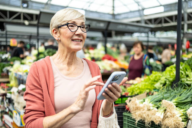 istock Elderly lady using smartphone at market 2193823850