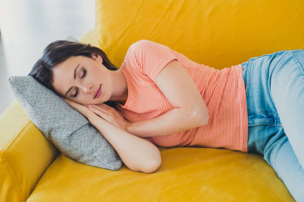istock Young woman resting peacefully on a vibrant yellow sofa with relaxed style 2193825390