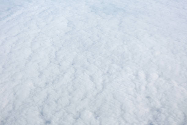 Aerial view over surface of white dense clouds
