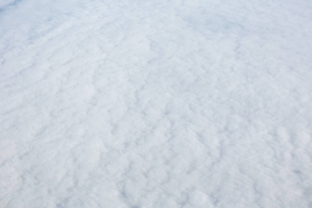 Aerial view over surface of white dense clouds