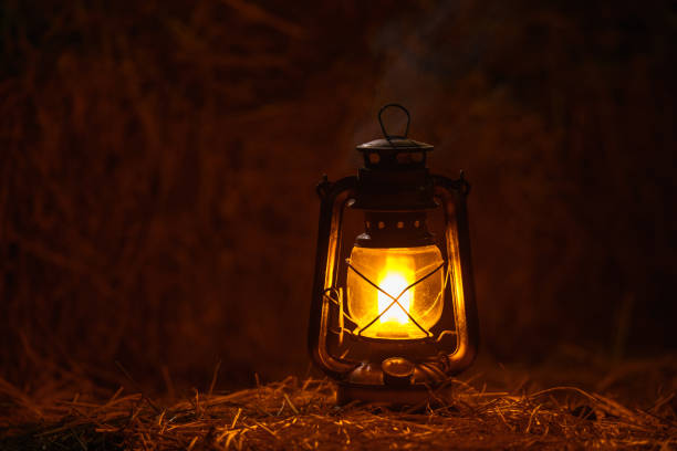 antique kerosene lamp with lights on a haystack in a barn at night