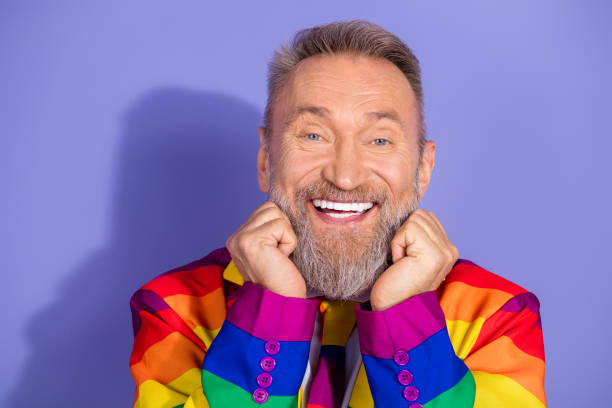istock Charismatic elderly man in rainbow suit beams with joy against violet background 2193831350