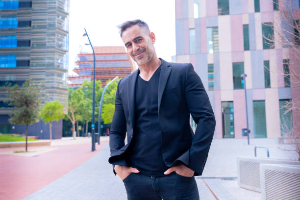 istock Smiling businessman in black suit posing confidently in urban setting. 2193833049