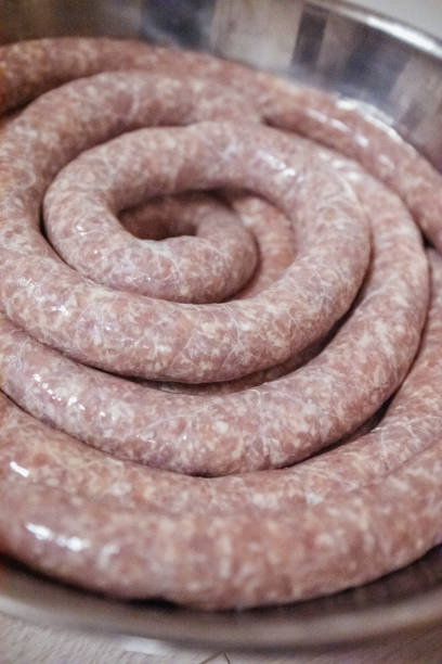 Mother and an adult son with Transylvanian roots,  making a traditional sausage for Christmas dinner at home using natural sausage casing.