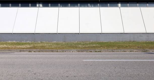 istock White and gray modern industrial building at the roadside. 2193834307