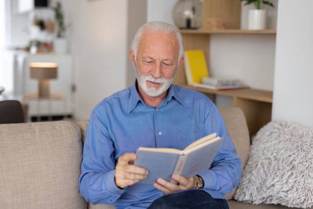 istock Elderly man enjoying a book in a cozy setting 2193835073