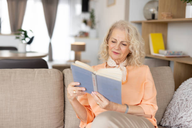 istock Senior woman indulging in a good book with joy 2193835075