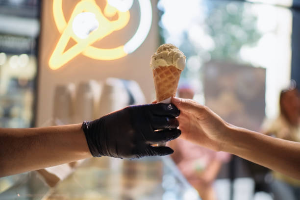 istock Ice cream seller giving ice cream cone to customer 2193838368