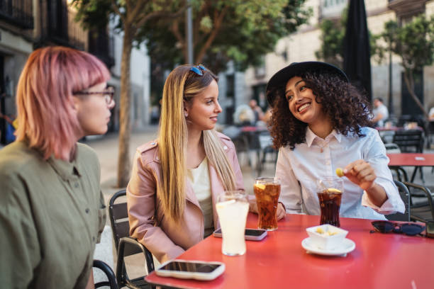 istock Three young women enjoying drinks and conversation at outdoor cafe 2193838510