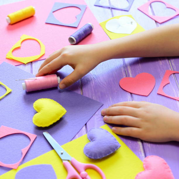 istock Small child made felt hearts. Children's hands on the table 2193839823