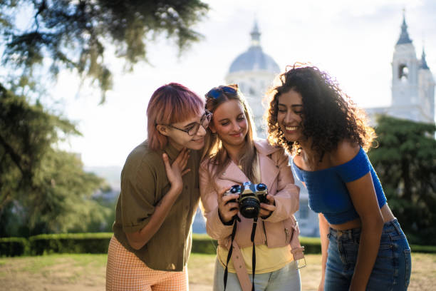 istock Three young women looking at photos on vintage camera 2193840817