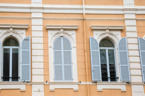 Shot looking up at wooden shutters and window boxes on a facade in Italy