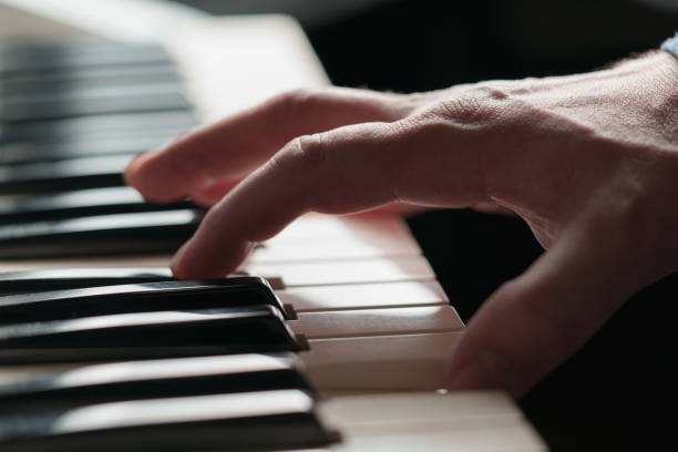istock A man is playing the piano, hands on the keys in close-up. 2193846320