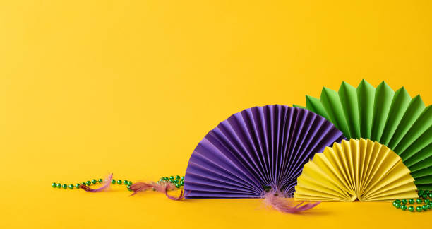 istock Brightly colored side view paper fans arranged against a vibrant yellow background, representing celebration and creativity 2193847928