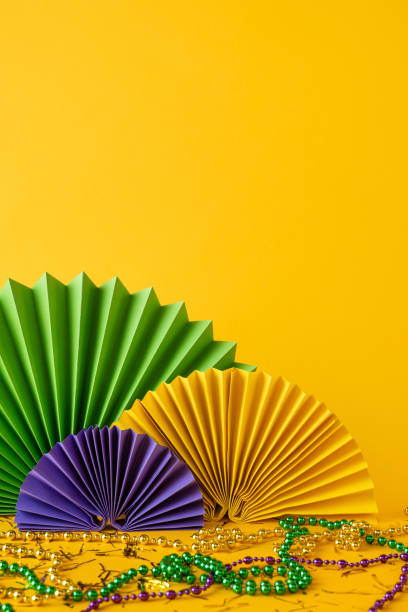 istock Bright yellow side vertical view backdrop showcasing green, purple, and gold decorations with festive beads, embodying the celebratory spirit of Mardi Gras 2193847956