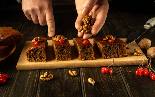 istock Hands skillfully arrange a delightful dessert on a rustic wooden board, garnishing with walnuts and viburnum. The warm, inviting atmosphere creates an enticing culinary experience 2193852393