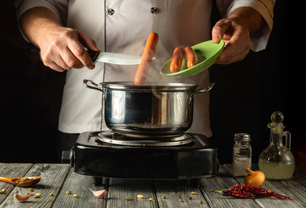 istock A skilled chef expertly tosses sausages into a bubbling pot on a stovetop, surrounded by colorful ingredients and spices at a cozy kitchen workspace, evoking warmth and culinary creativity 2193852535