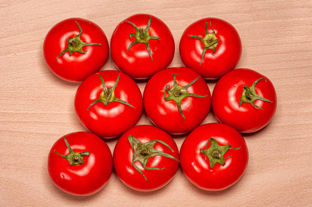Many rows of tomatoes on a wooden board