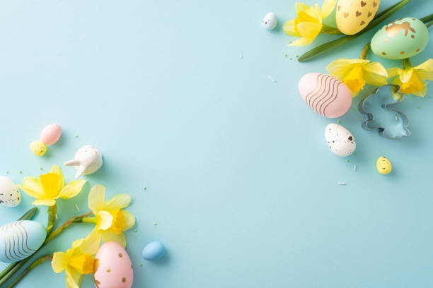 istock Easter-themed arrangement featuring pastel-colored eggs and yellow flowers on a blue surface 2193856386