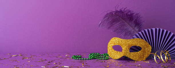 istock Mardi Gras side view decorations including a golden mask, beads, and glitter, arranged on a purple background to symbolize festive celebration themes 2193856464