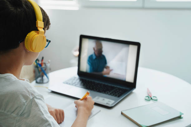 istock Boy learning online with headphones and laptop, attentive 2193856758
