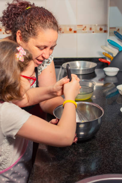 istock Mother holds the bowl for her daughter to move the workmanship, while they talk. 2193857542