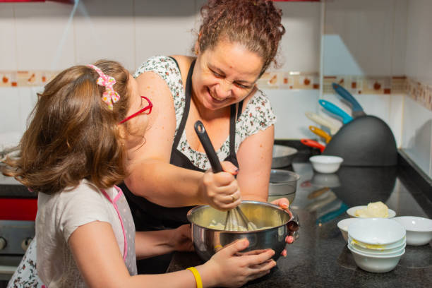istock mother and daughter happy in the kitchen while making a dish in the kitchen. 2193858287