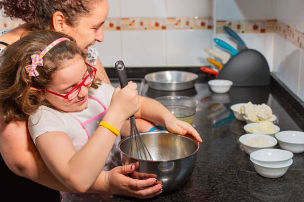 istock mother and daughter playing affectionately while making a cake in their kitchen. 2193858410