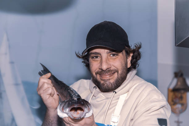 istock Smiling male holding freshly caught fish in hands 2193858536