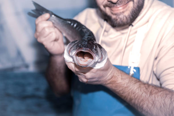 istock Smiling male holding freshly caught fish in hands 2193858537