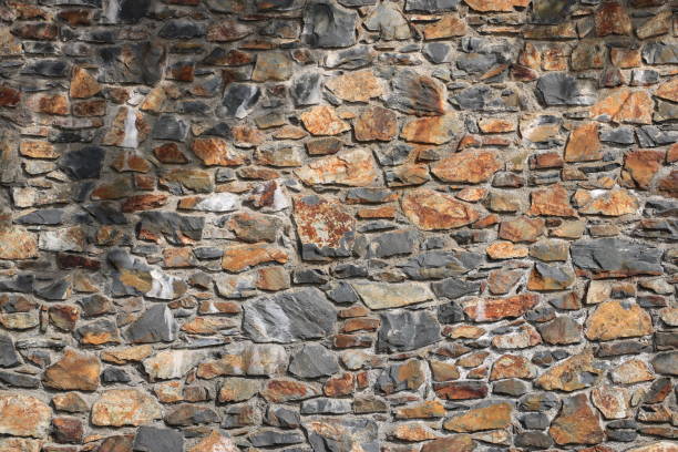 istock Stacked stone brick wall. Stone cladding wall made of natural grey rocks 2193861103